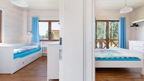 A bedroom with a bed, a desk, and a window.