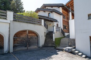 Un bâtiment doté d’un escalier en bois, d’un pont de pierre et d’une porte en bois.