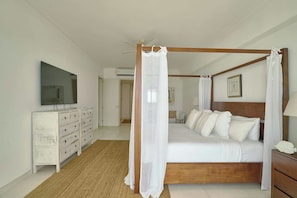 A bedroom with a four-poster bed, a television on the wall, and a dresser. - ®{3BR~Hemingway~Retreat}@JuanDolio+Pool (Juan Dolio)