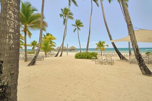 A beach with palm trees, lounge chairs, and a clear view of the ocean. - ®{3BR~Hemingway~Retreat}@JuanDolio+Pool (Juan Dolio)