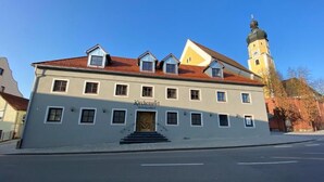 A large building with a sign 'Kirchenwirt Hotelgasthof' and a tower with a dome.