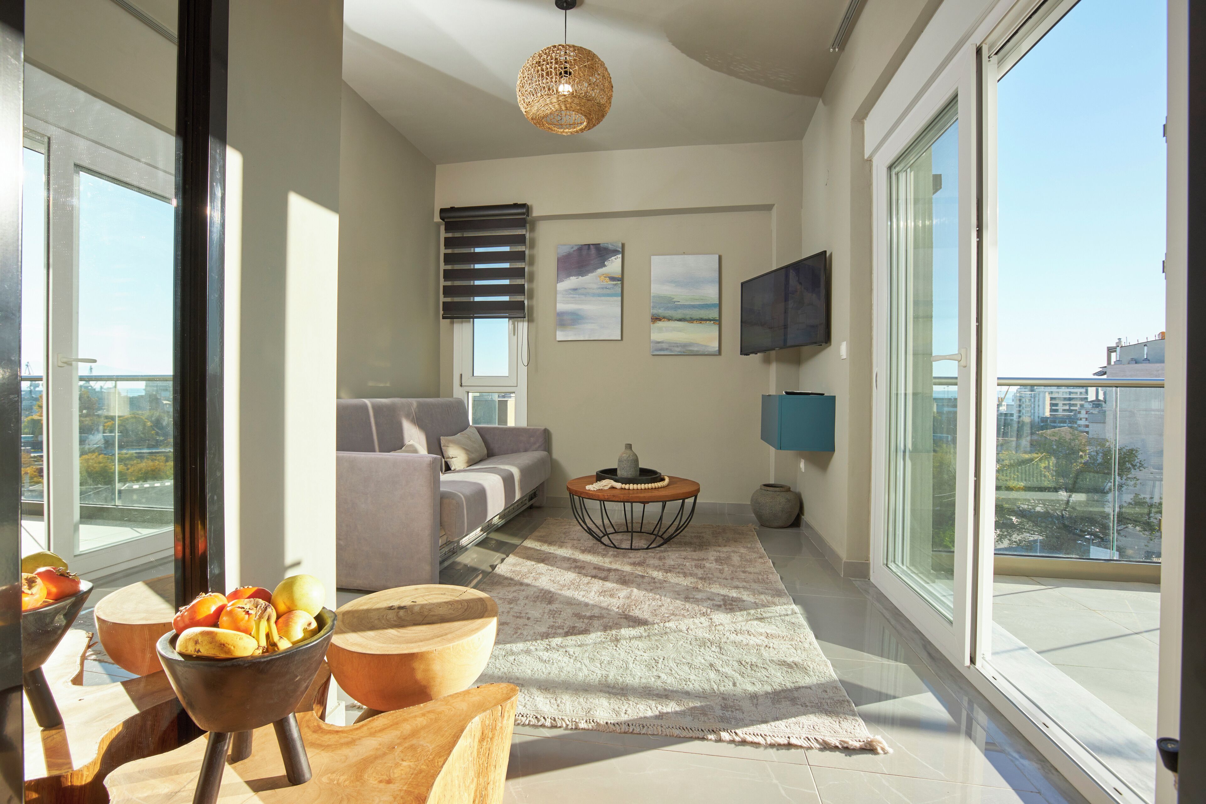 A modern living room with a sofa, coffee table, and a view of the city.