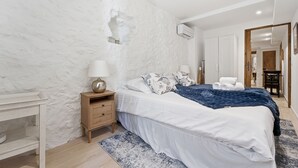 A bedroom with a bed, bedside table, lamp, and a wardrobe. - Robin's Nest – Cocon au cœur du Vieil Antibes (Antibes)