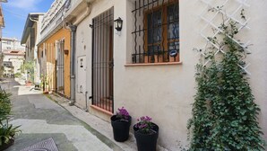 A narrow street with buildings, a metal gate, and potted plants. - Robin's Nest – Cocon au cœur du Vieil Antibes (Antibes)