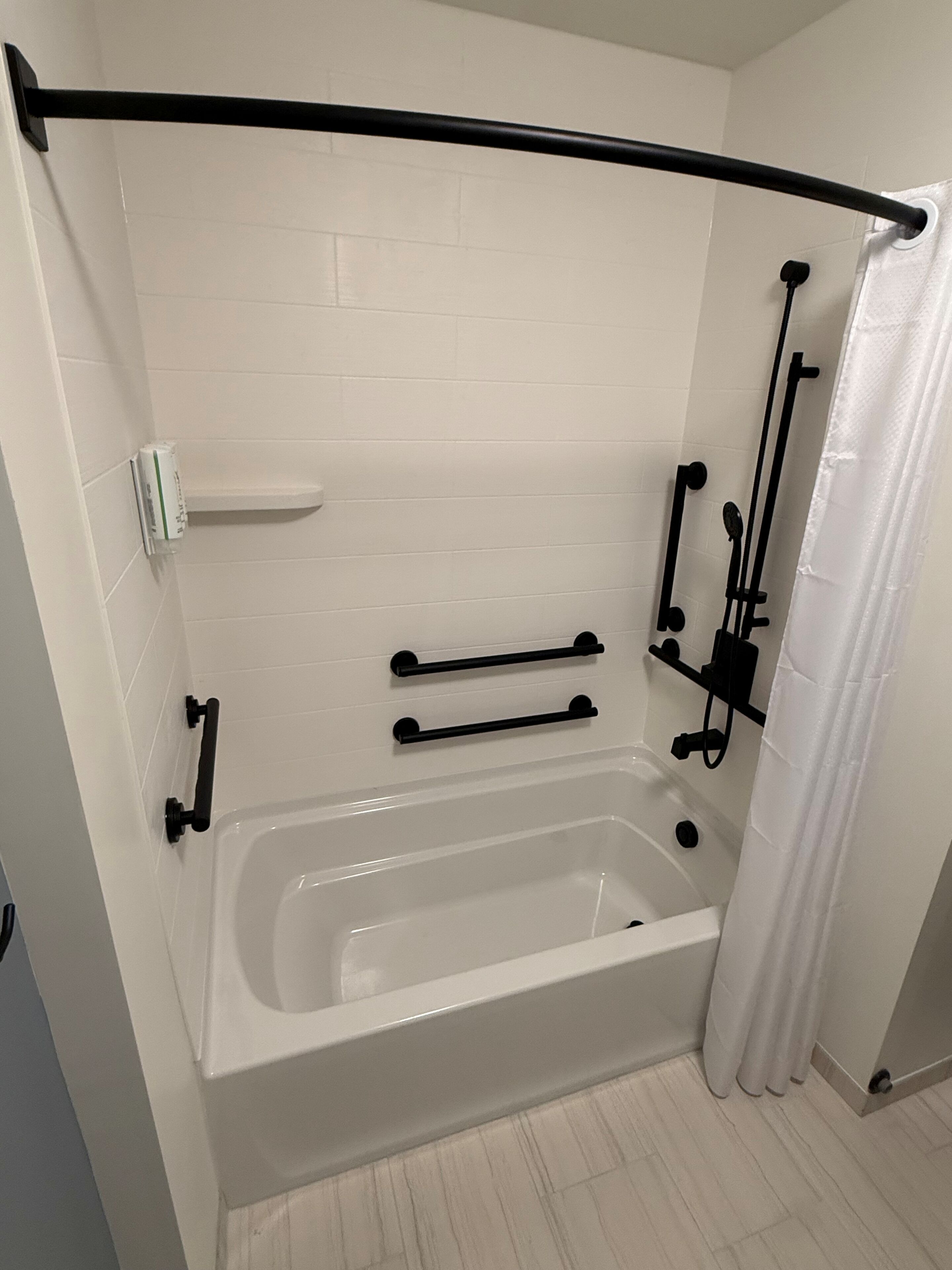 Une salle de bain avec une baignoire, un rideau de douche et un porte-serviettes.