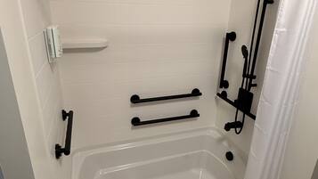 Une salle de bain avec une baignoire, un rideau de douche et un porte-serviettes.