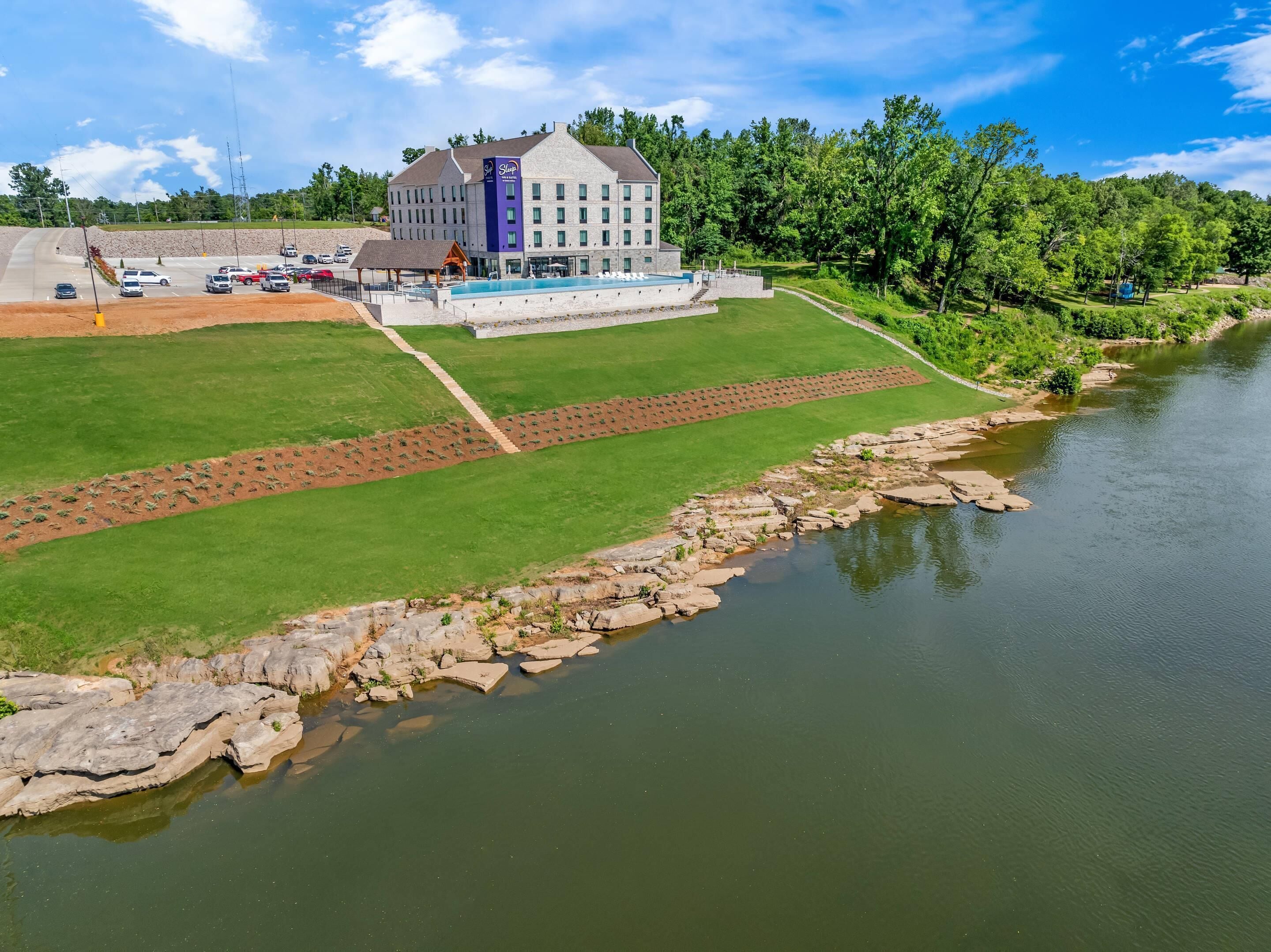 Un hotel con piscina, una zona techada y vistas al río.