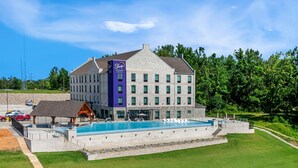 A hotel with a swimming pool, outdoor seating, and a stone facade. - Sleep Inn & Suites Savannah Tennessee Riverfront (Savannah)
