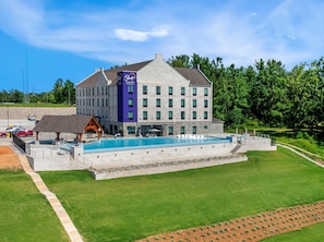 A hotel with a swimming pool, outdoor seating, and a stone facade. - Sleep Inn & Suites Savannah Tennessee Riverfront (Savannah)