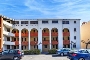 A multi-story building with balconies, a parking lot, and a clear sky. - L'Ancrage à Port Leucate - A 1km de la plage (Leucate)