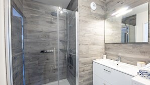 A modern bathroom with a glass-enclosed shower, a white vanity with a mirror, and a wooden wall paneling. - L'Escale de Césarine - 1 km de la plage (Carnac)