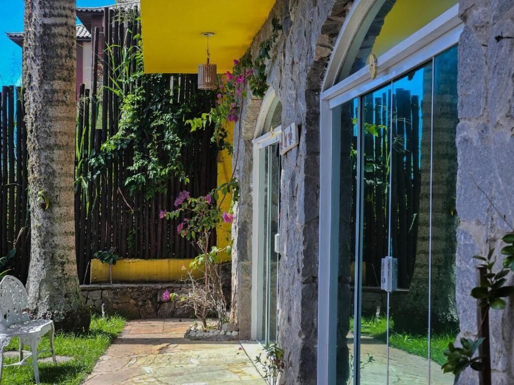 A courtyard with a stone pathway, a white chair, and a glass door leading to a room.