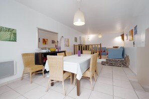 Un espace repas comprenant une table, des chaises et un luminaire suspendu.