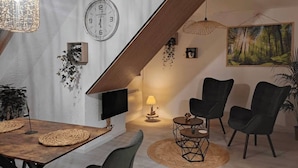 A modern living room with a dining area, a staircase, and a painting on the wall.