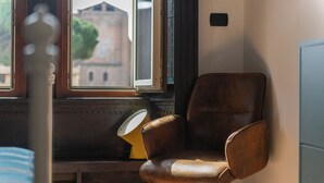 A room with a window, a chair, and a bed.