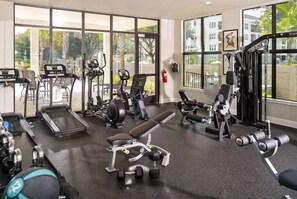 A gym with cardio machines, weightlifting equipment, and benches. - 5BR Family Home w/ Private Pool  / Near Disney (Davenport)
