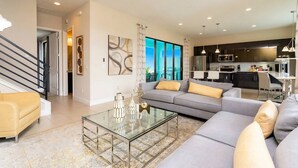 Ein modernes Wohnzimmer mit einer Couch, einem Couchtisch und einer Treppe, die in eine weitere Ebene führt.