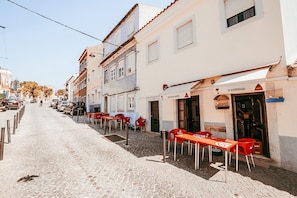 Eine Kopfsteinpflasterstraße mit Außenbereich und einem Restaurant namens 'O SOSSEGOSO'.