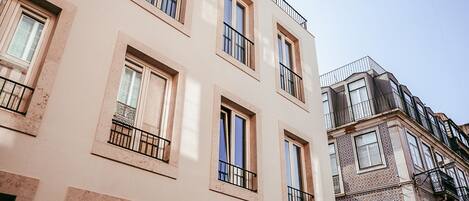 A multi-story building with balconies, large windows, and a mix of architectural styles.