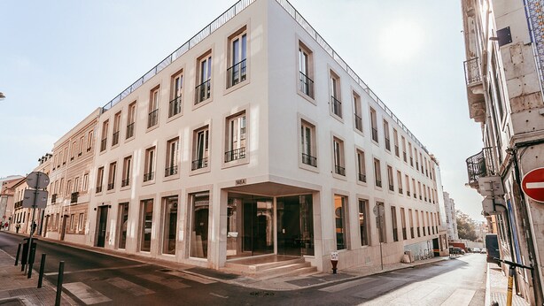 A multi-story building with a flat facade, large windows, and a ground-floor entrance. - Elegant Sophisticated Campo Ourique by GT House (Lisbon)