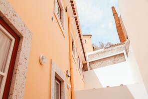 A building with a sloped roof, a chimney, and a window with a white frame. - Kalathos House 1 With Terrace By Gt House (Lisbon)