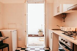 A compact kitchen with a refrigerator, stove, and sink. - Kalathos House 1 With Terrace By Gt House (Lisbon)