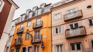 A multi-story building with balconies, a blue directional sign, and a door marked with the number 98. - Central Typical Lisboa by GT House (Lisbon)