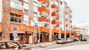 A multi-story building with balconies, a parking sign, and a storefront. - Amadora Terrace View By Gt House (Amadora)