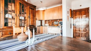 A wooden dining table with a striped table runner, a vase, and candles. - Amadora Terrace View By Gt House (Amadora)