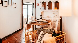 A dining area with a round table, chairs, and a wicker sofa with patterned cushions. - Altura Beach Villa by GT House (Castro Marim)