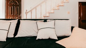A bed with white pillows, a dark green bedspread, and a wooden staircase in the background. - Altura Beach Villa by GT House (Castro Marim)