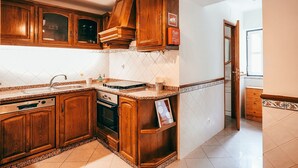 Uma cozinha com armários de madeira, forno embutido e pia de aço inoxidável.