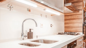 Una cocina moderna con un lavamanos doble, grifo de acero inoxidable y una estufa integrada.