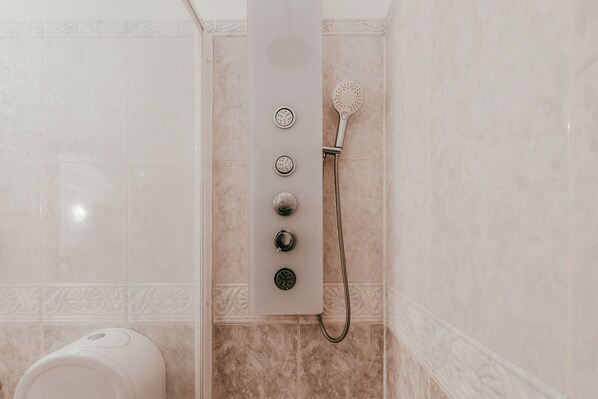 A bathroom with a shower, a toilet, and a wall-mounted control panel. - Beach House By Gt House (Silves)
