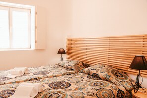 A bedroom with two beds, a window, a lamp, and a wall-mounted shelf. - Kalathos House 2 With Terrace By Gt House (Lisbon)