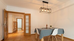 Un espace repas comprenant une table, des chaises et un luminaire suspendu.