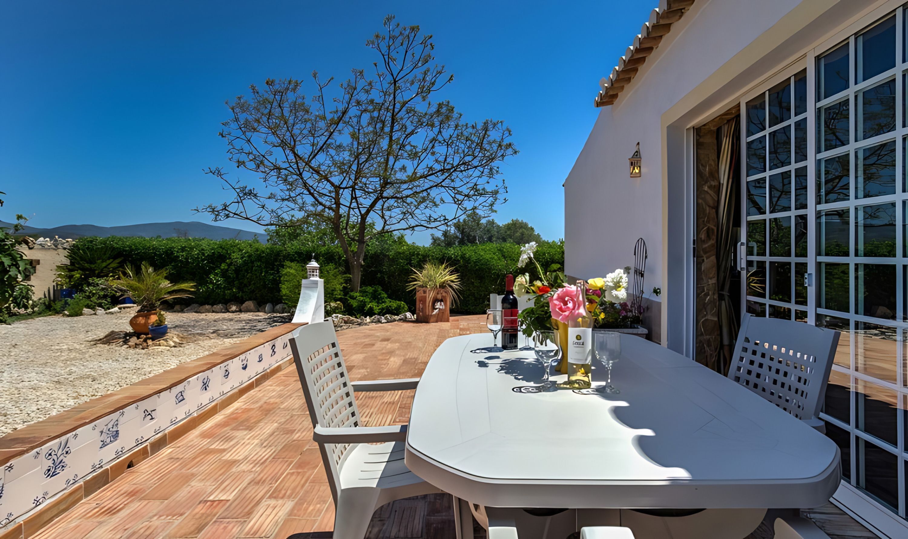 An outdoor patio with a table, chairs, and a decorative lantern.
