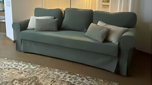 A living room with a sofa, a floor lamp, and a patterned rug. - Goleg Boutique Apartment By Gt House (Golega)