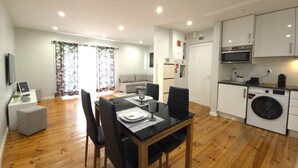 A modern apartment with a dining area, kitchen, and living space. - Sesimbra Terrace Escape By Gt House (Sesimbra)