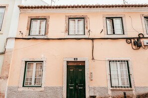 A building with multiple windows, a green door, and visible electrical wiring. - Studio S Jos By Gt House (Lisbon)