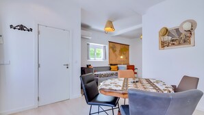 Ein modernes Wohnzimmer mit Essbereich, einer Couch, einem Couchtisch und einer Weltkarte an der Wand.