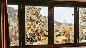 A window with a view of a natural landscape, including trees and shrubs. - Oliveira s Houses By Gthouse (Sintra)