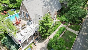 Une maison à deux étages dotée d’un patio couvert, d’une piscine et d’un jardin bien entretenu.