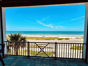 A balcony with a view of a beach, a fence, and some vegetation. - Beautiful Oceanfront House with Pool in Flagler Beach (Flagler Beach)