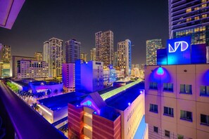 A nighttime cityscape with illuminated buildings and a prominent hotel sign. - Brickell Area| Free Parking| Balcony| Rooftop Pool (Miami)