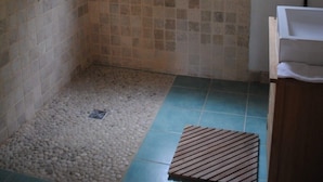 Ein Badezimmer mit Dusche, Fenster und Waschbecken.