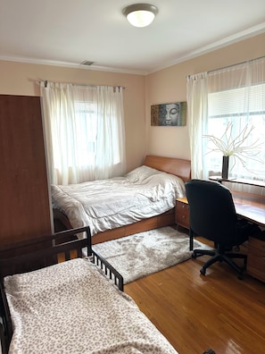 Un dormitorio con una cama, un escritorio y una silla.