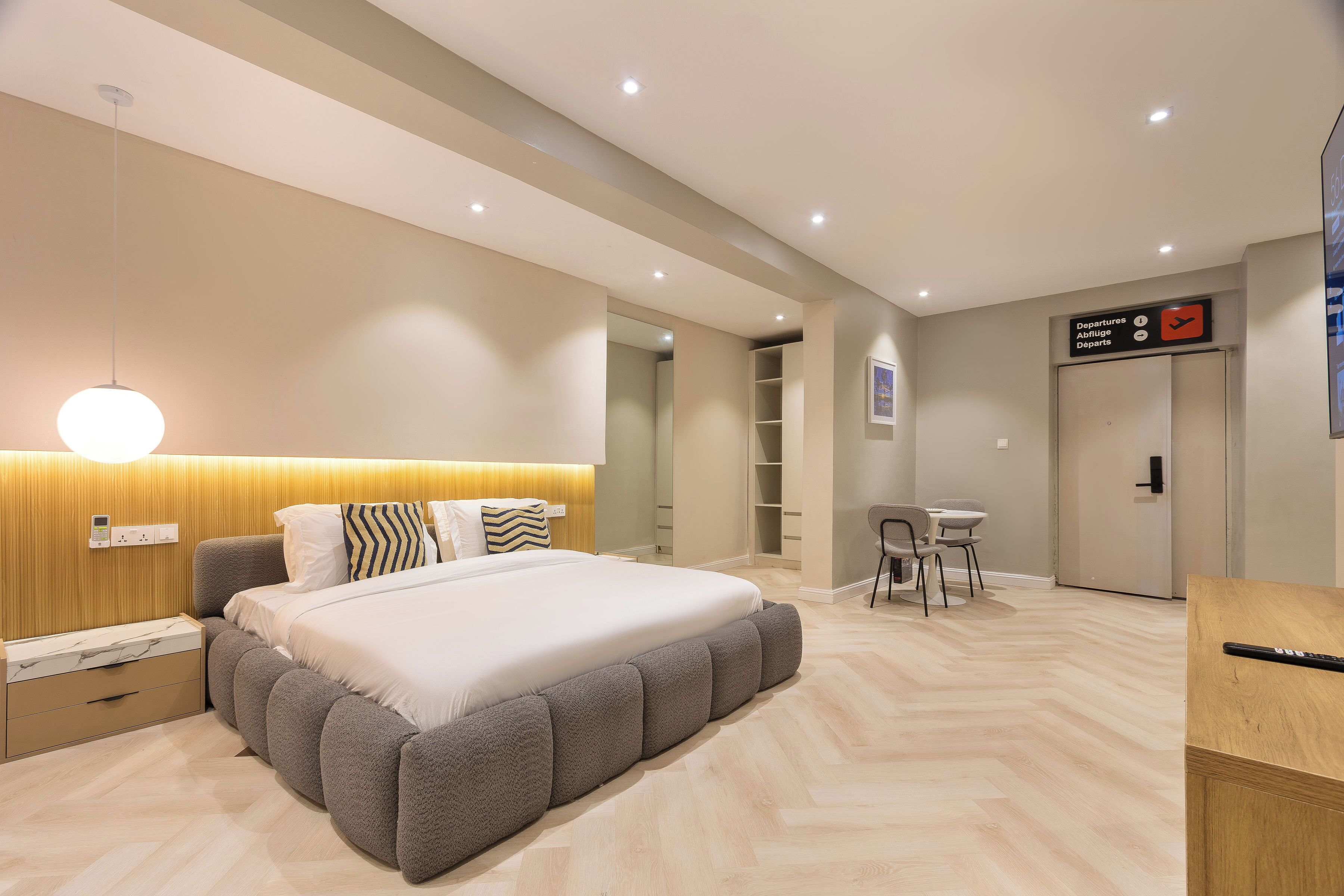 A modern hotel room with a large bed, bedside tables, a desk, and a chair.