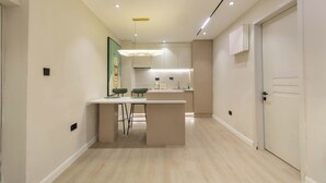 A modern kitchen with a central island, recessed lighting, and a minimalist design. - The District Lekki (Lekki)