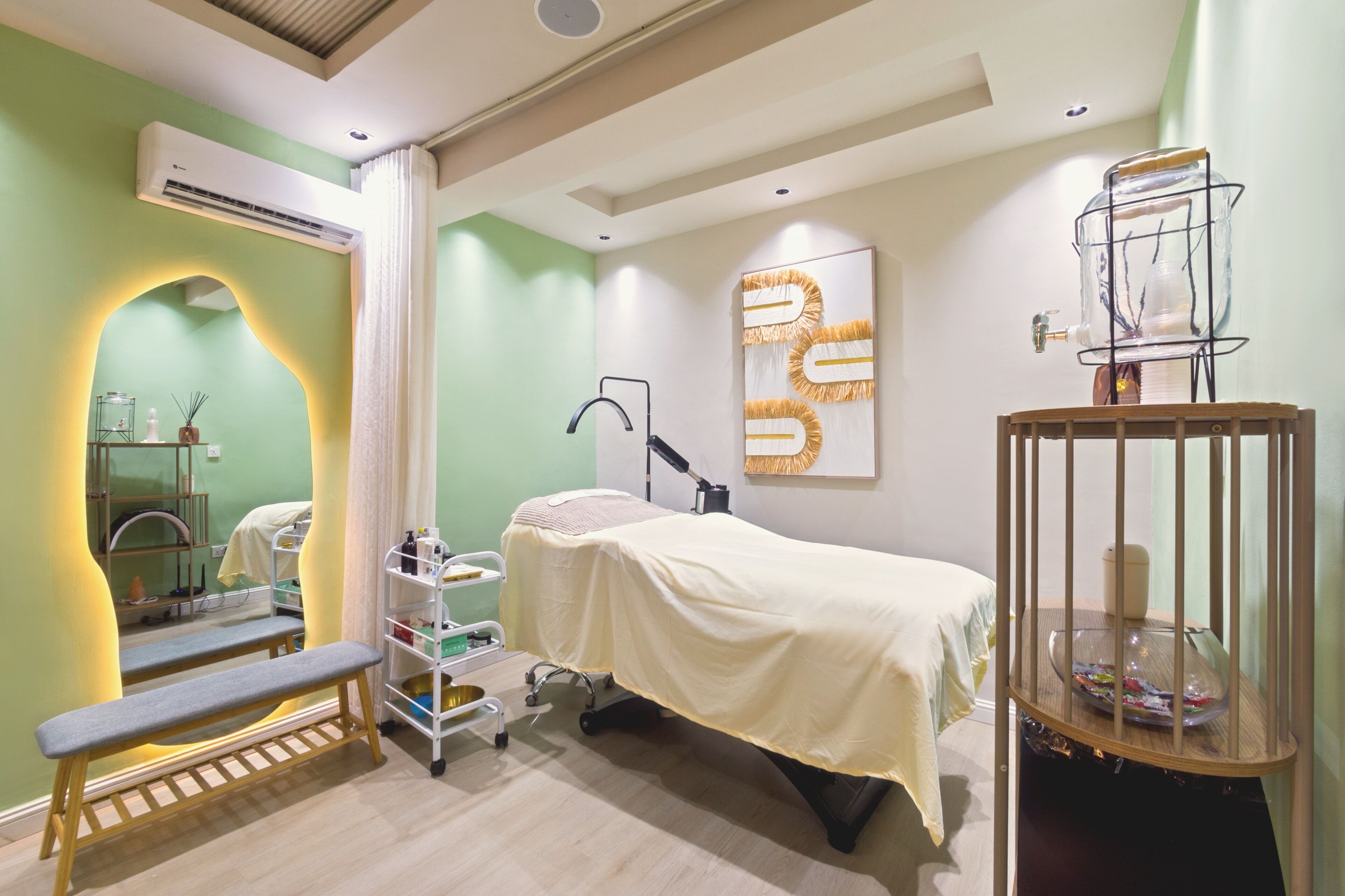 A room with a bed, a bench, a shelf with toiletries, an air conditioning unit, and a decorative item on the wall.